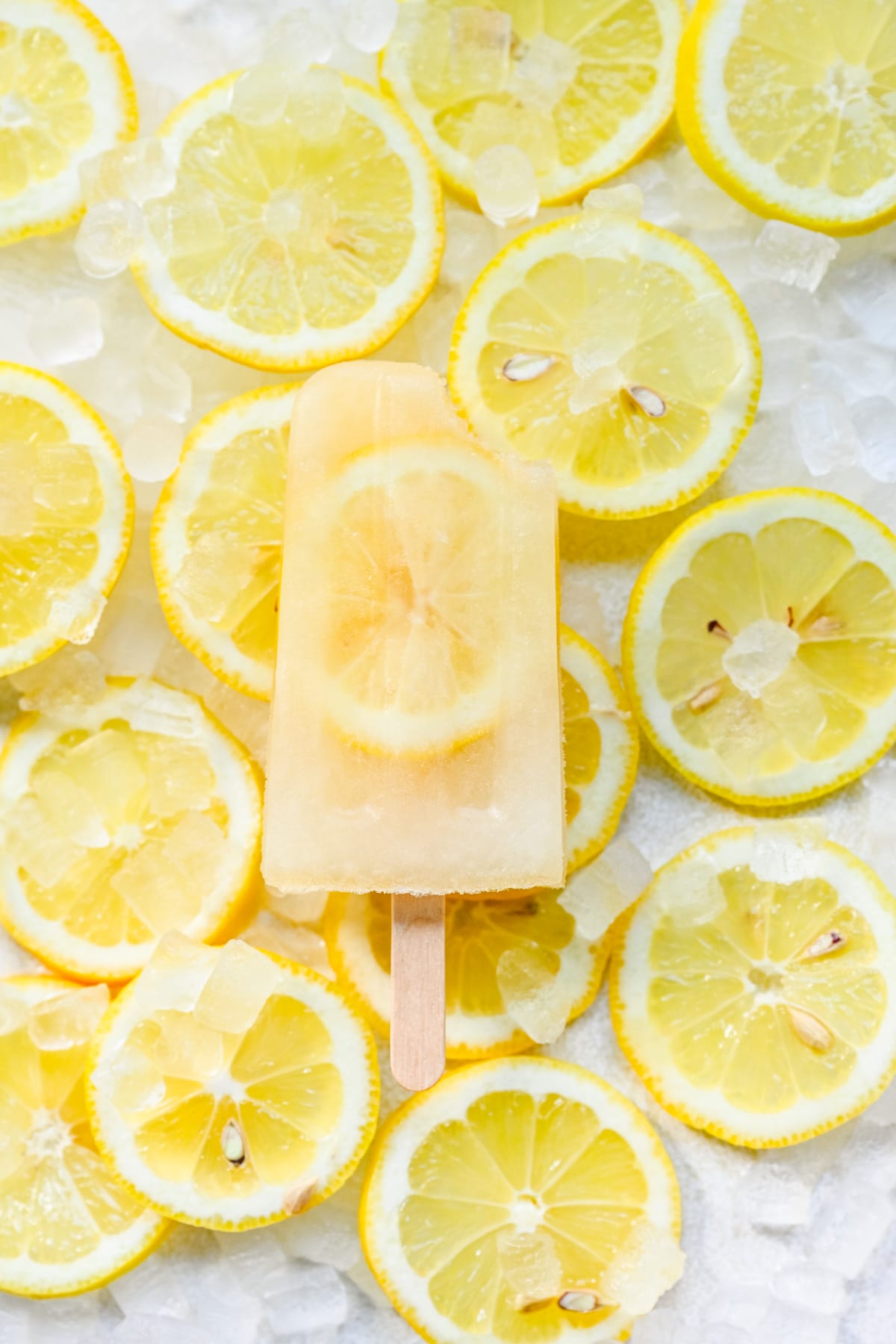 Overhead of a finished lemon popsicle on top of lots of lemon slices.