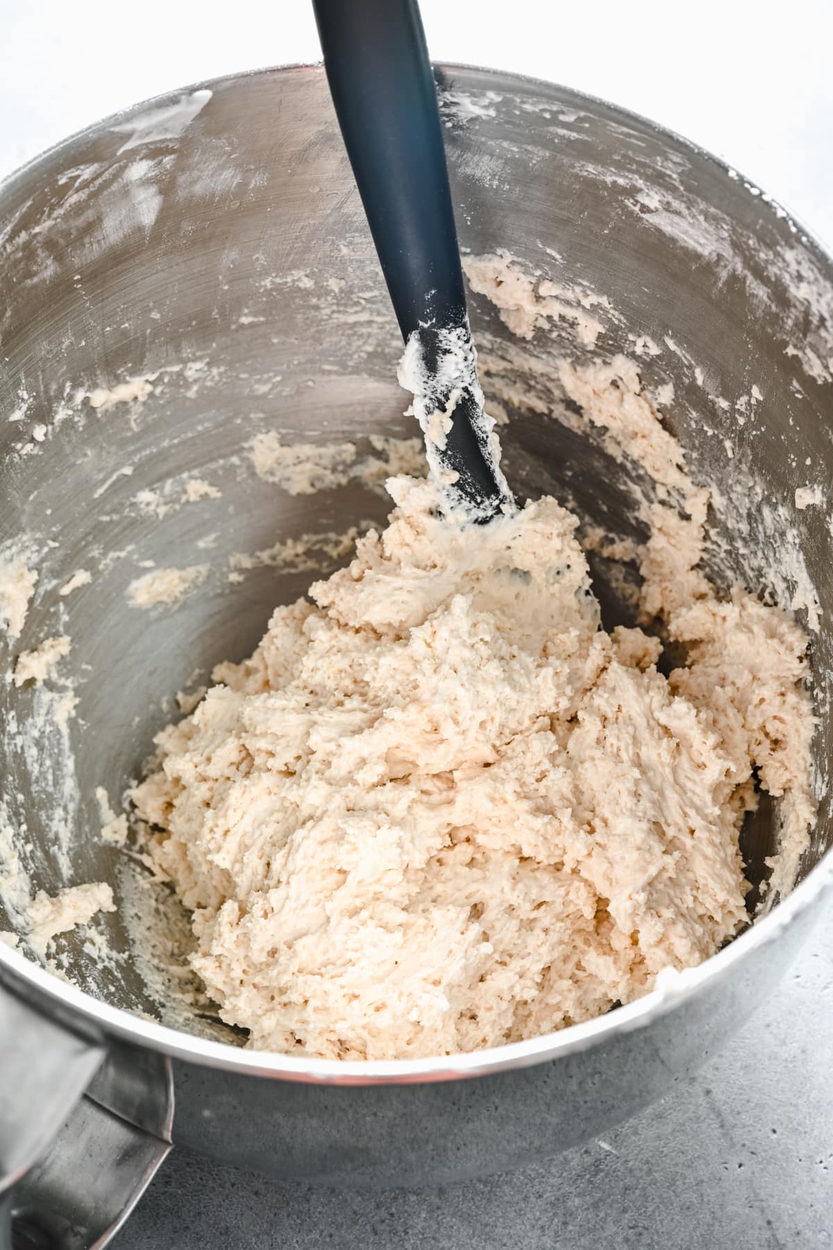 Vegan ladyfinger batter in a mixing bowl with a spatula.