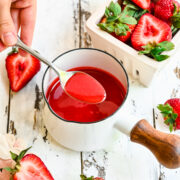 Overhead of a spoon scooping up some of the strawberry coulis.