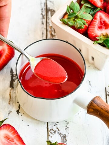 Overhead of a spoon scooping up some of the strawberry coulis.