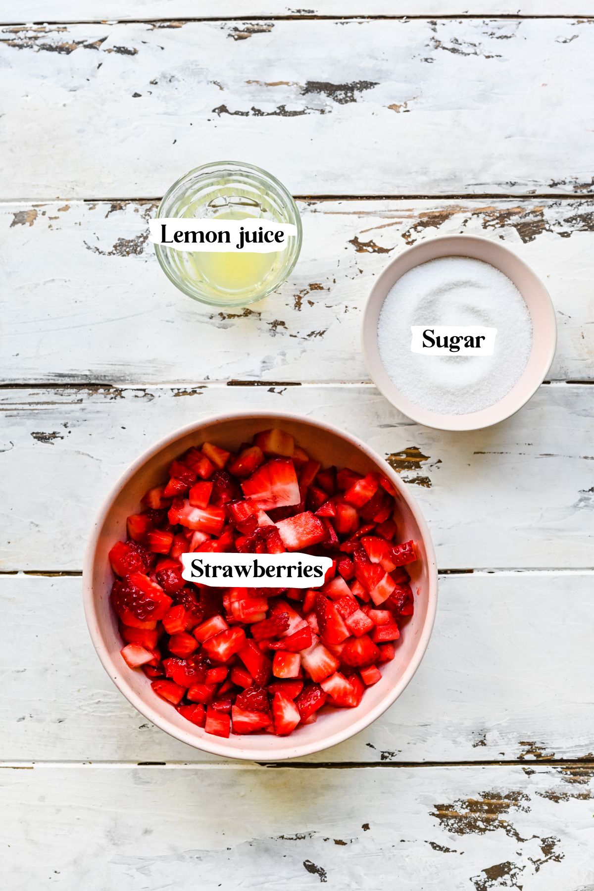 Overhead of the strawberry coulis ingredients including sugar and lemon juice.