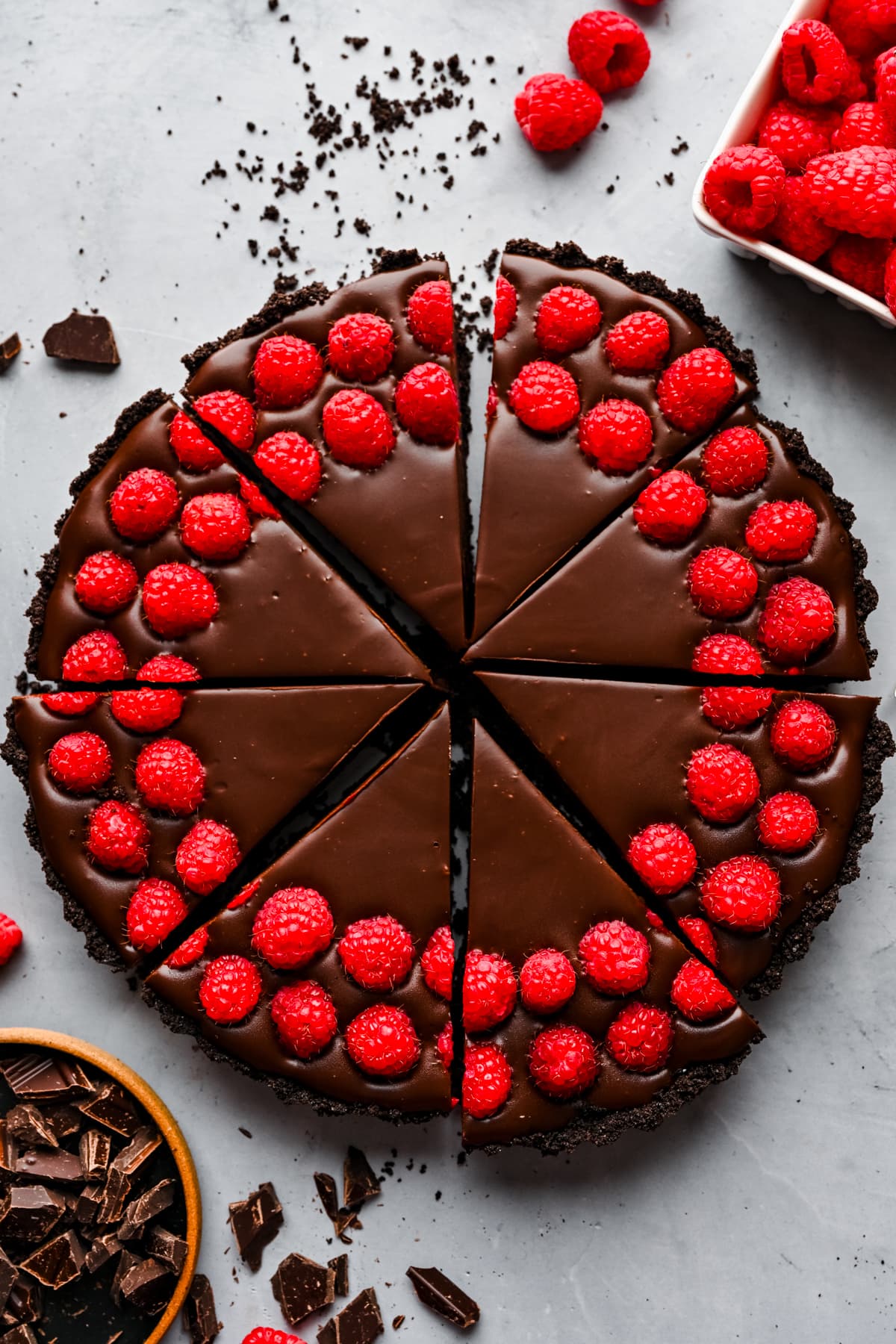 Overhead view of chocolate raspberry tart cut into slices. 