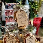 side view of 3 cocktail in a jar kits with christmas tree in background.