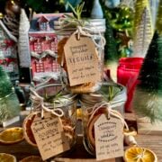 side view of 3 cocktail in a jar kits with christmas tree in background.