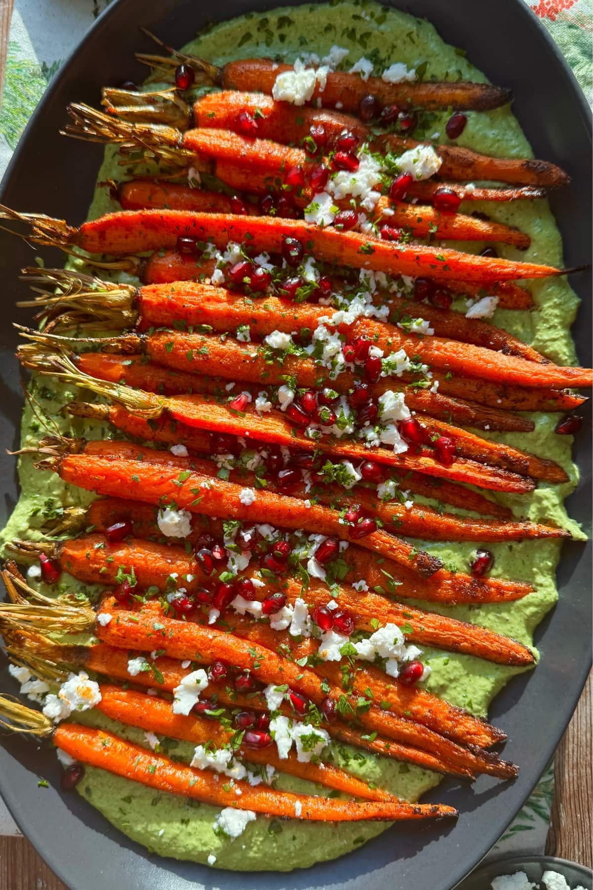 Overhead view of carrots atop green goddess on a plate.