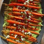 Overhead view of carrots atop green goddess dip.