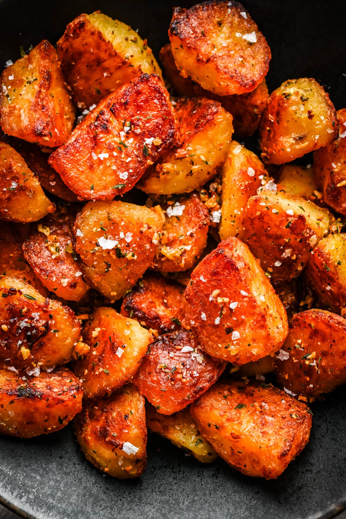 Close up overhead view of crispy roast potatoes in a bowl.