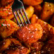 Crispy roasted potatoes with herbs and sea salt, close-up image.