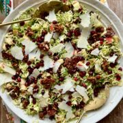 Close up view of shaved brussels sprout salad in a large bowl.