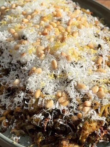 close up view of Roasted shredded brussels sprouts on a platter topped with parmesan.