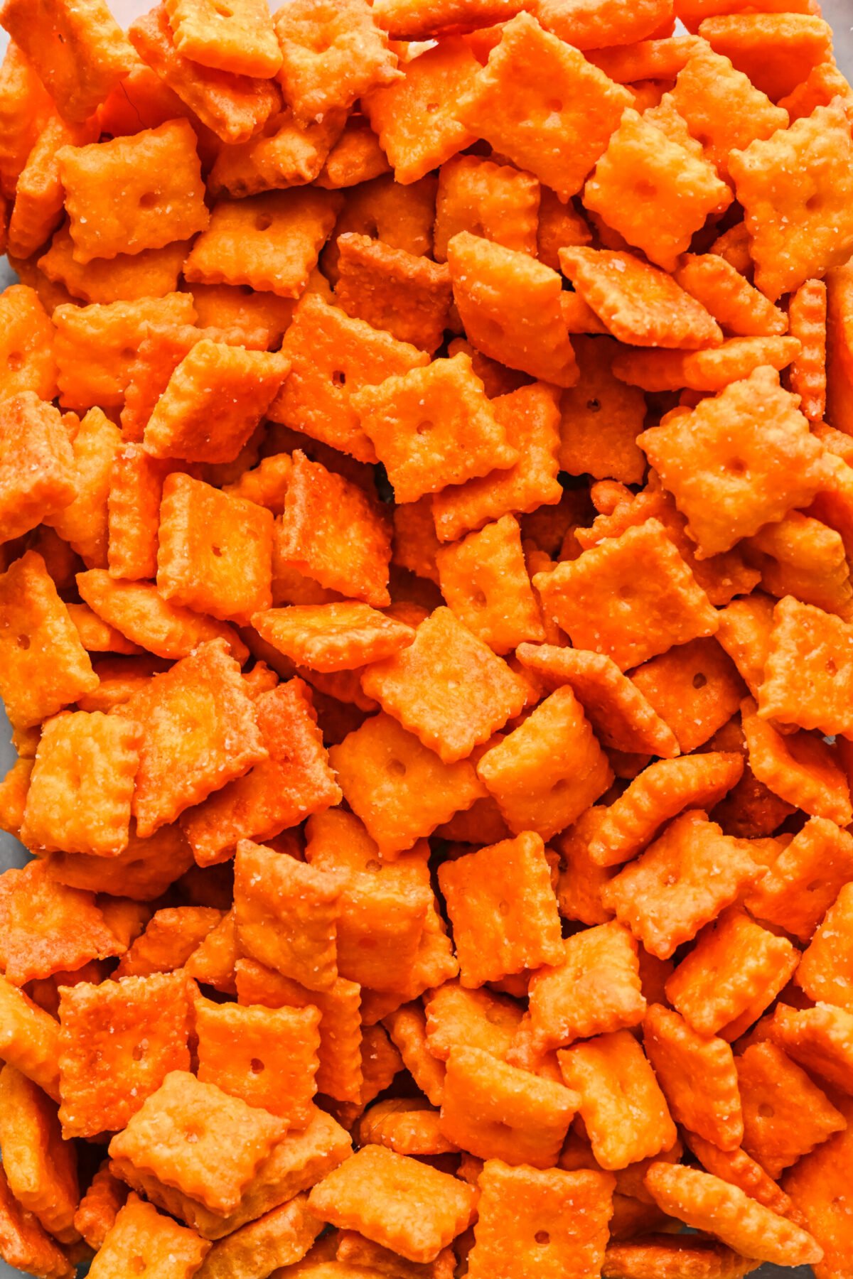 Overhead view of a layer of cheez its on a sheet pan.