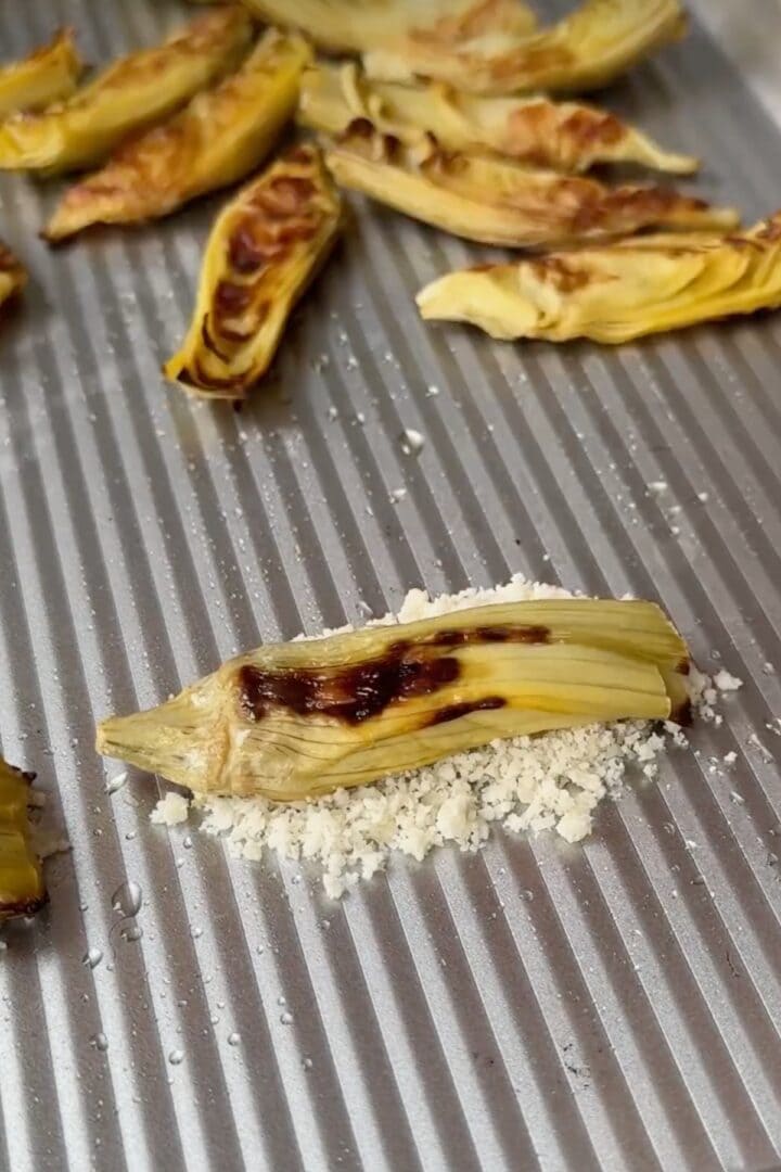 Placing artichoke atop parmesan.