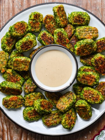 Overhead view of broccoli tots surrounded by honey mustard.