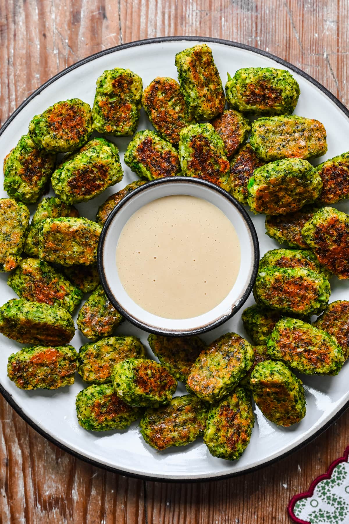 Overhead view of broccoli tots surrounded by honey mustard.