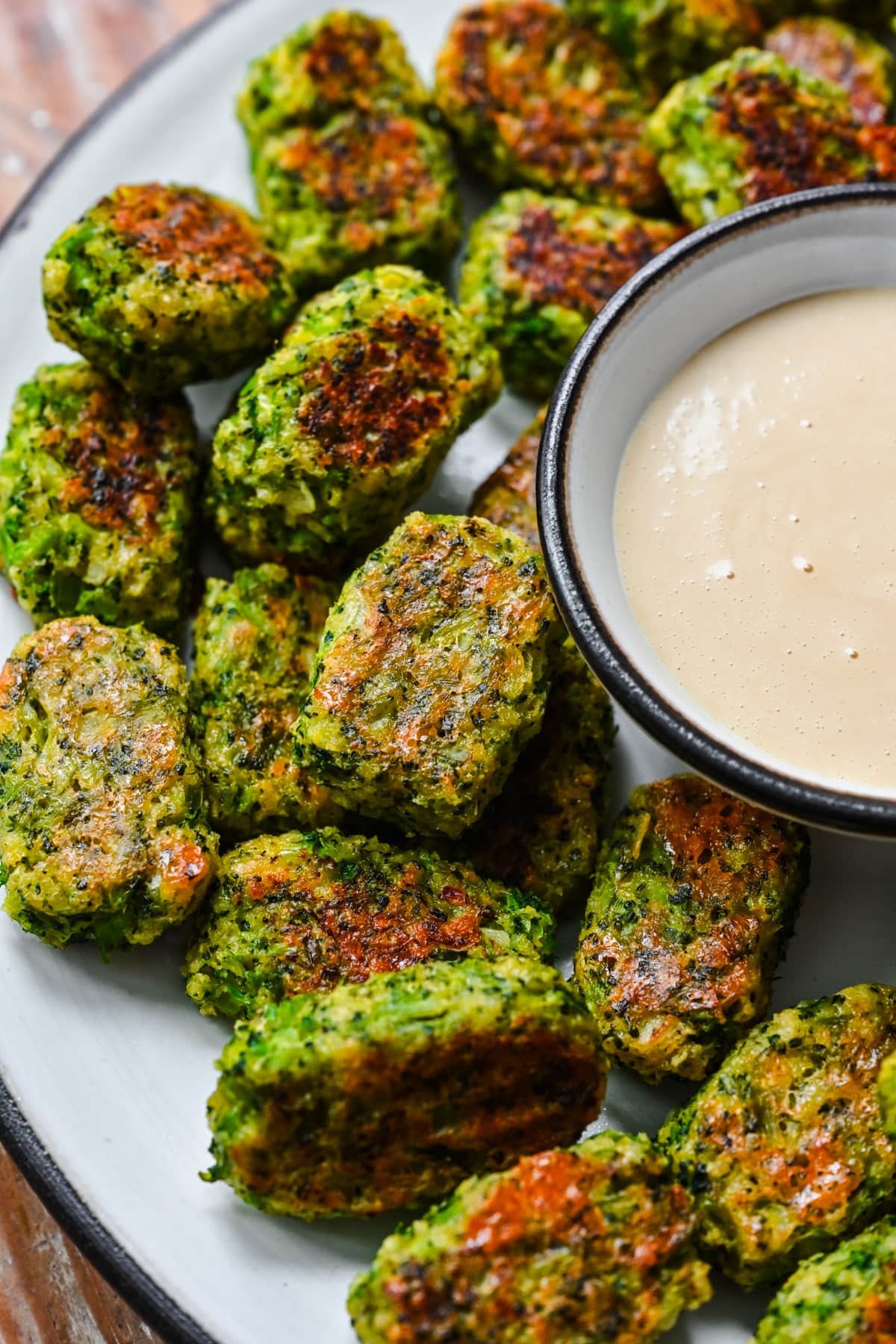 Overhead view of broccoli tots surrounded by honey mustard.