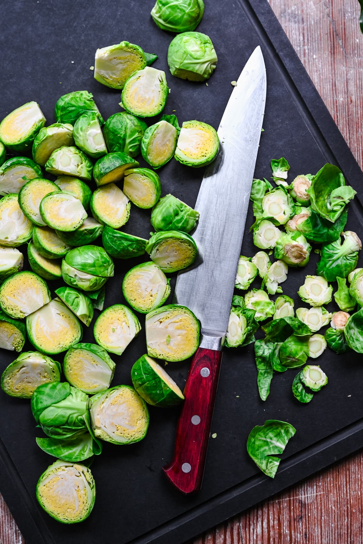 Halved brussels sprouts on a cutting board.