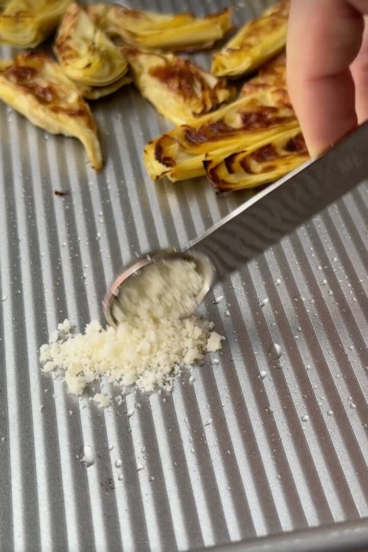 Placing parmesan down on a sheet pan.