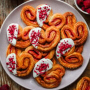 Overhead view of white chocolate dipped raspberry palmiers on a plate.