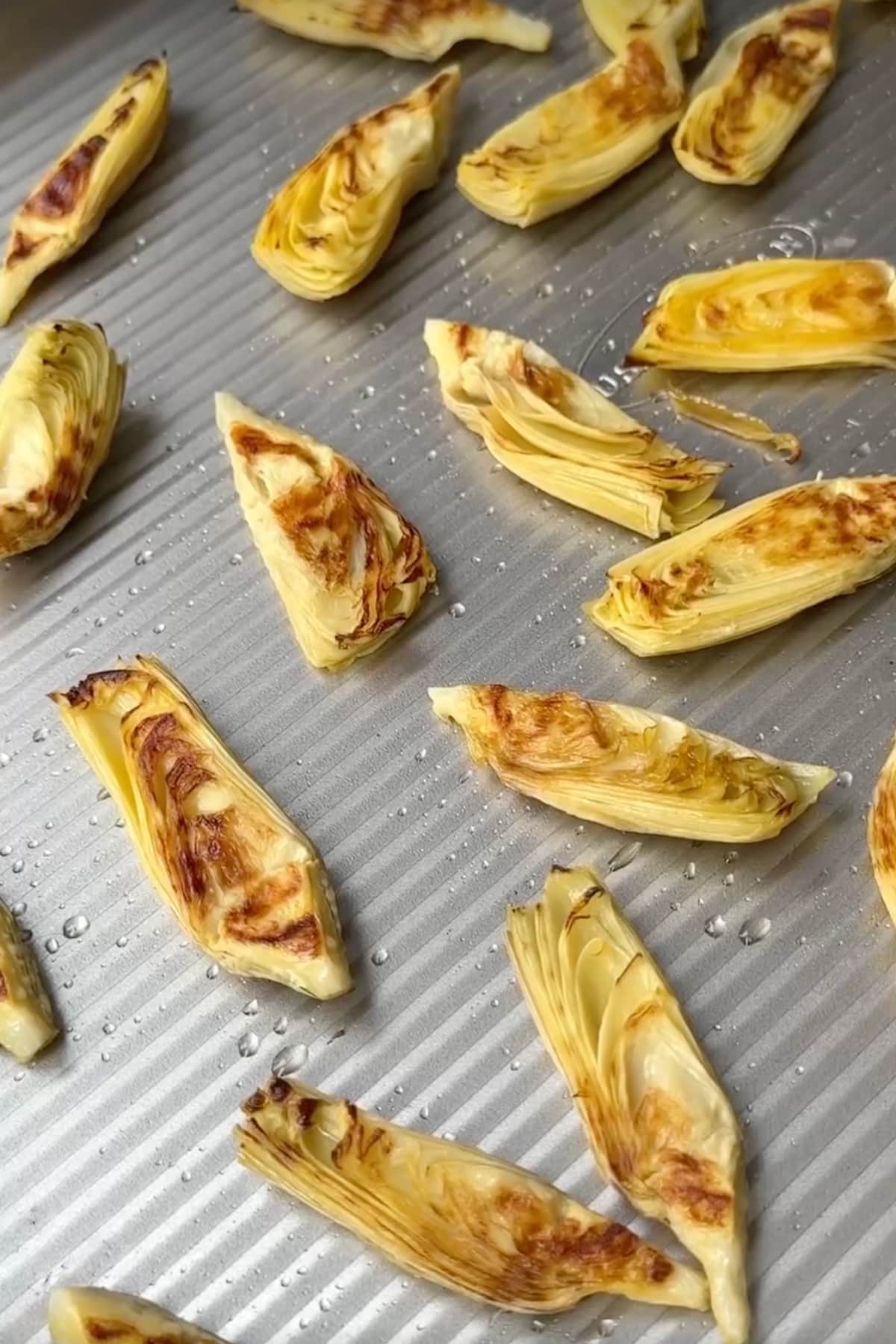 Roasted artichokes on a sheet pan.