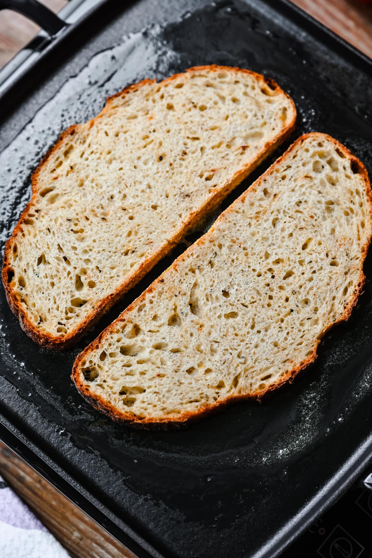 Overhead view of bread toasting on a pan.