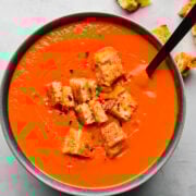 Creamy tomato soup with crunchy croutons and fresh herbs. Perfect comforting meal with savory flavors and crispy texture.