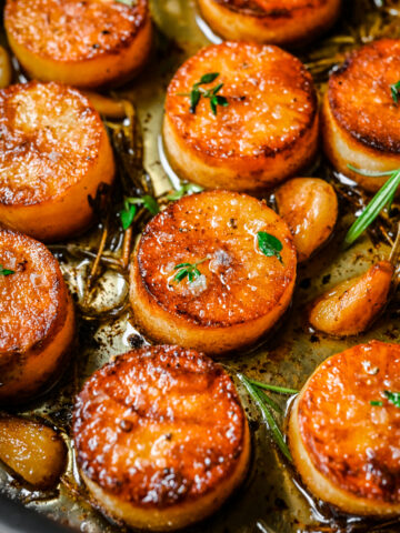 Overhead view of fondant potatoes in a sheet pan.