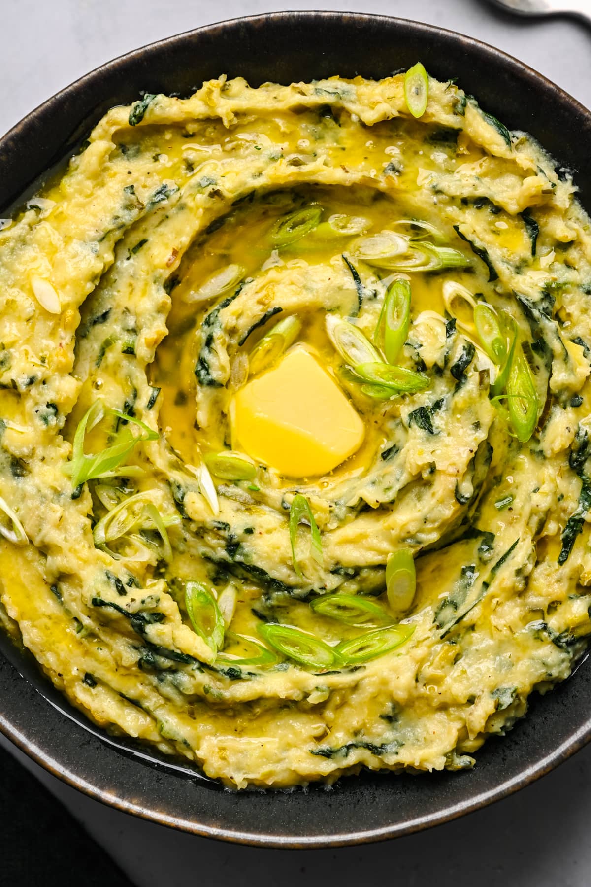 Overhead view of colcannon in a black bowl.