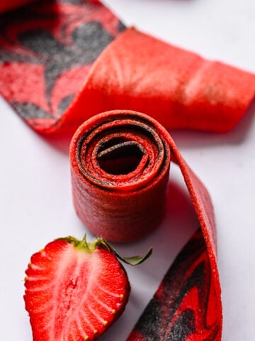 Strawberry fruit roll up on white background.