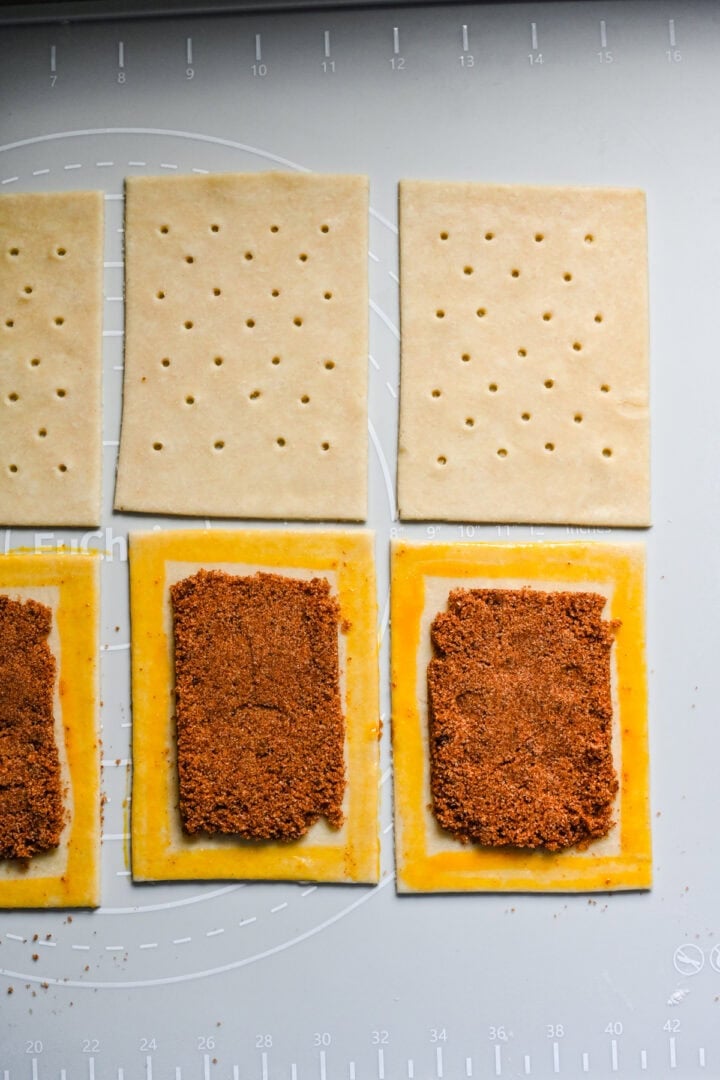 Pop tart dough with brown sugar cinnamon filling in the middle and egg yolk around the border.
