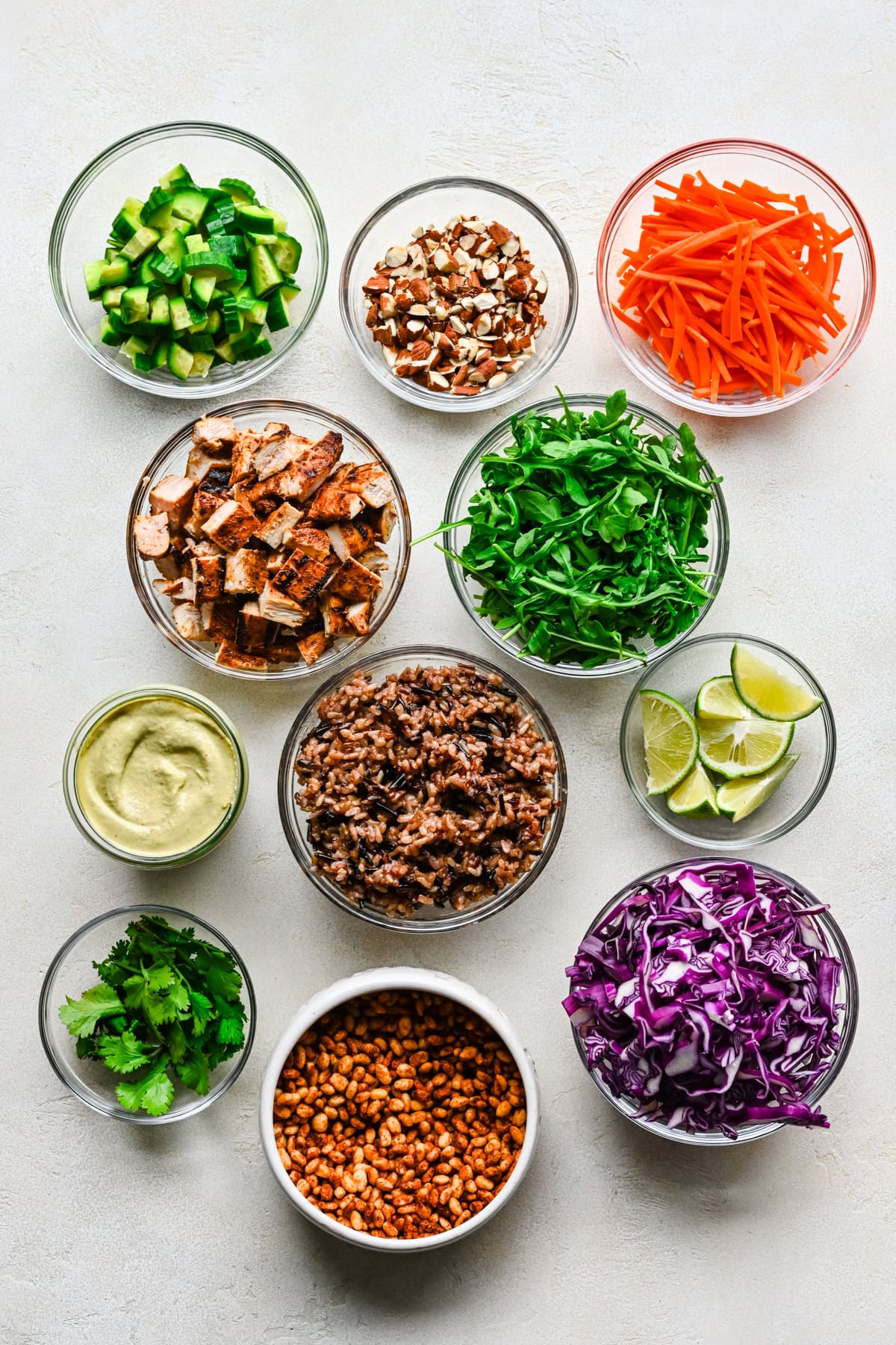 Overhead view of crispy rice bowl ingredients, including chicken and cashew dressing.