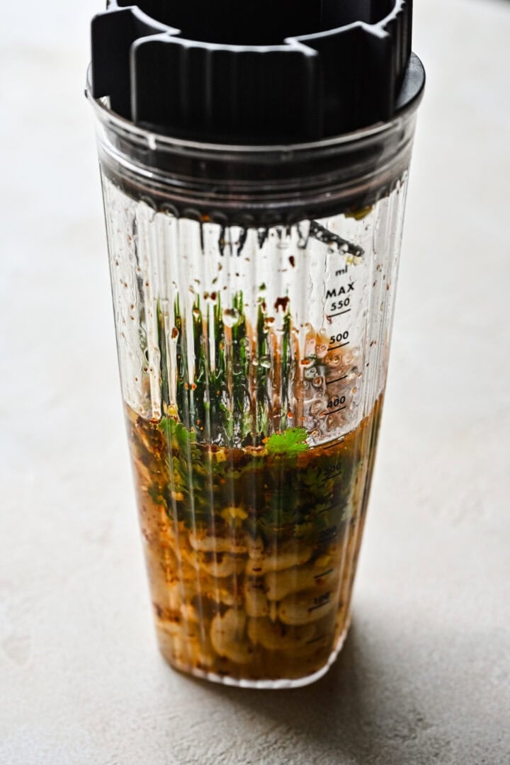 Side view of dressing ingredients in a blender.