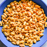 Crunchy coated peanuts in a dark blue bowl.