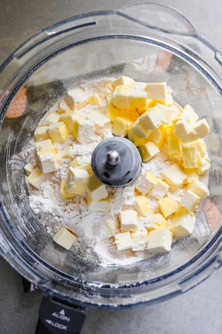 Overhead view of butter and dry ingredients in a food processor.