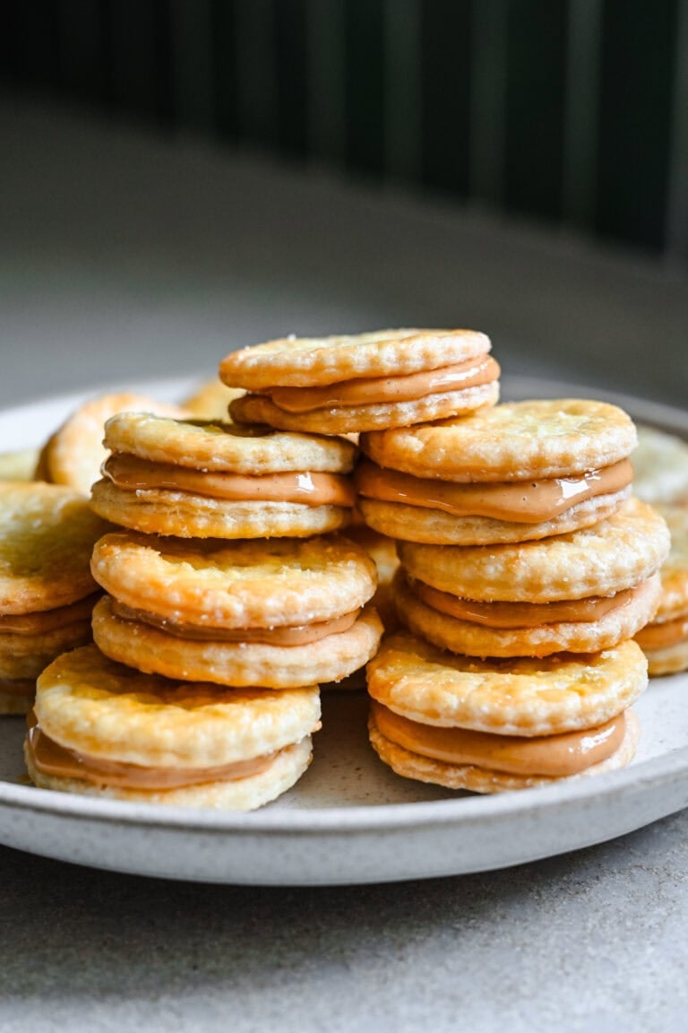 Flaky potato cracker cookies with chocolate filling, freshly baked, on a white plate.