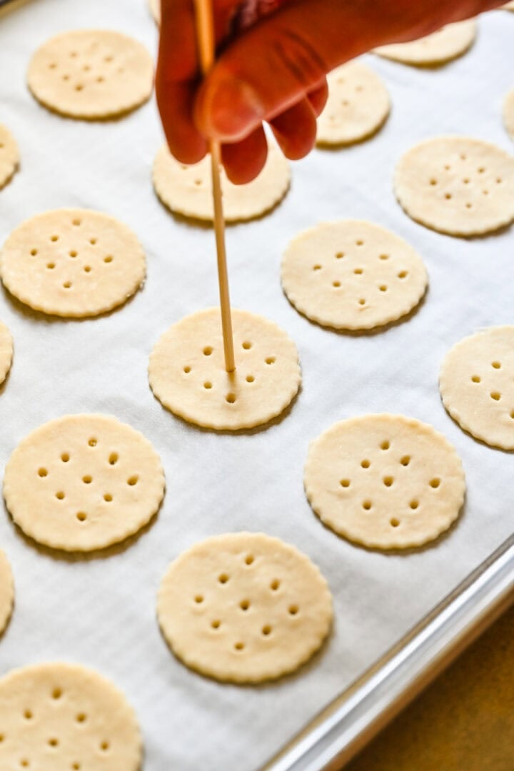 Poking holes into the crackers with a skewer.