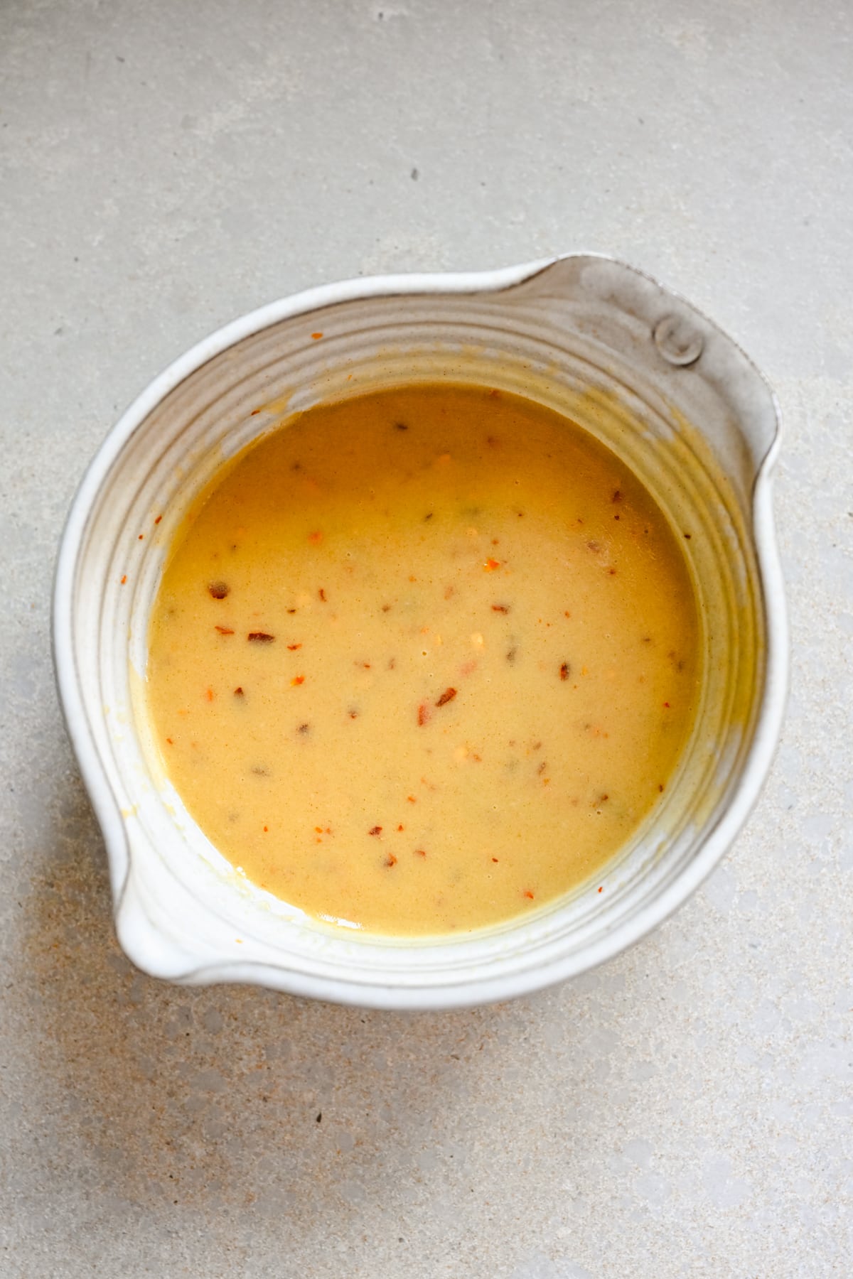 Overhead view of hot honey dressing in a bowl.