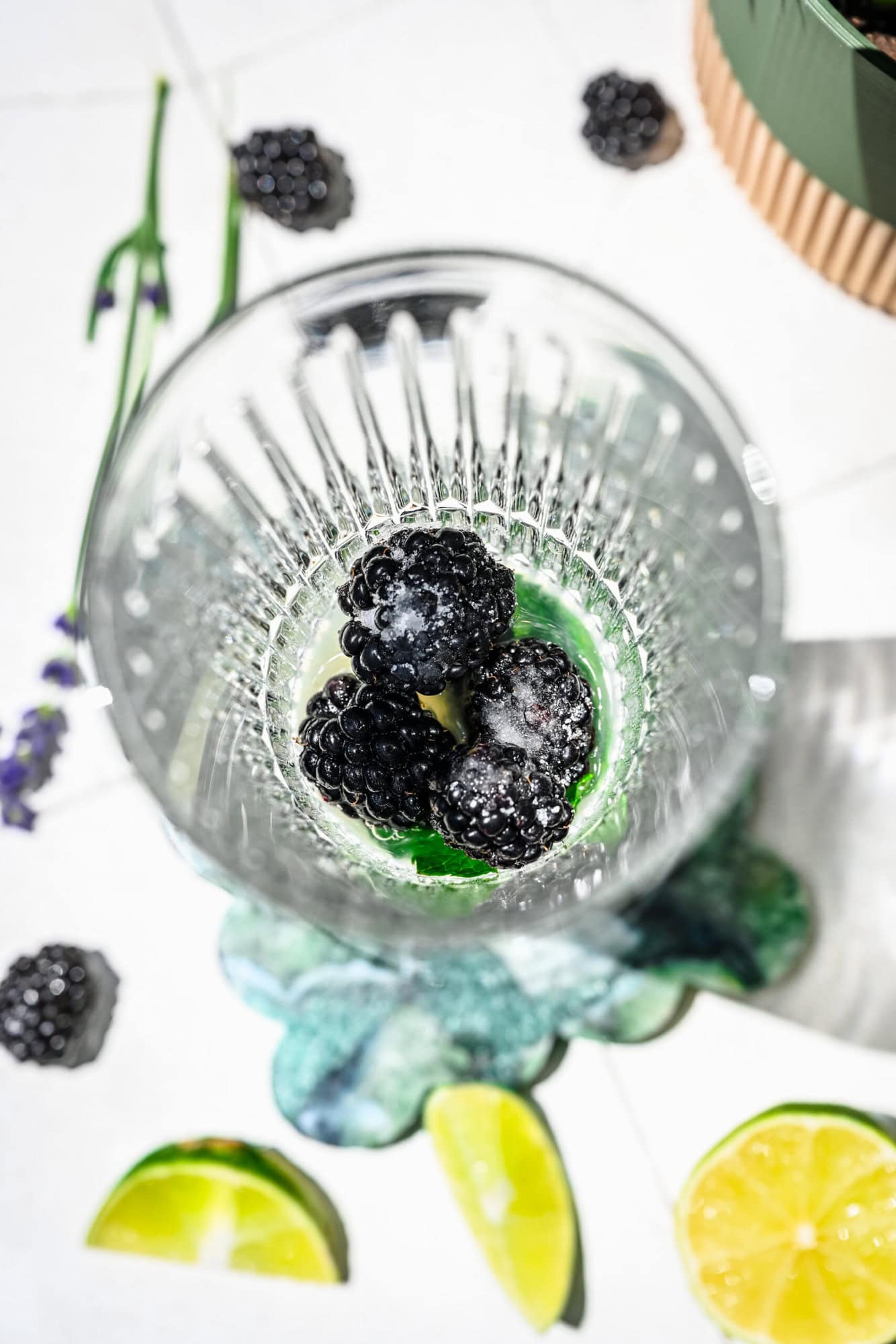 Blackberries, mint, sugar and lime juice in a highball glass.