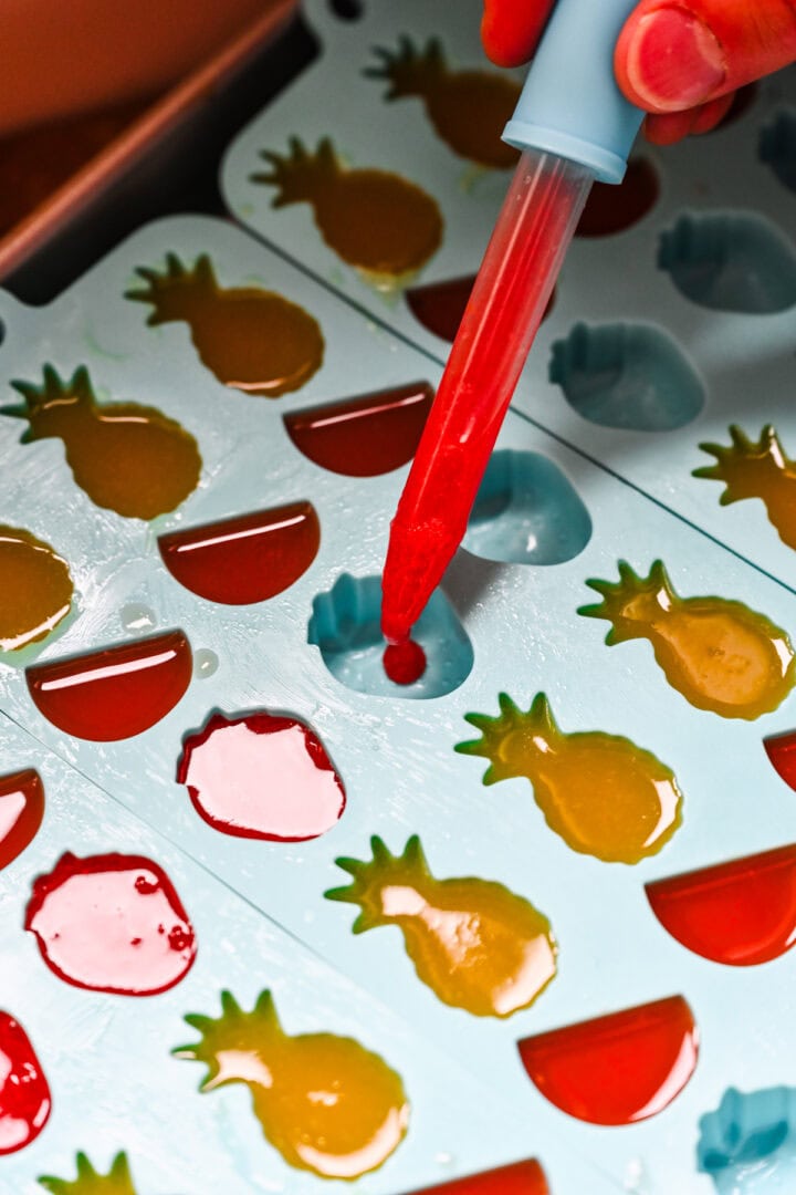 Dropping mixture into fruit snack molds.