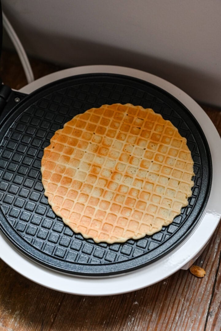 Waffle cone inside waffle maker after cooking.
