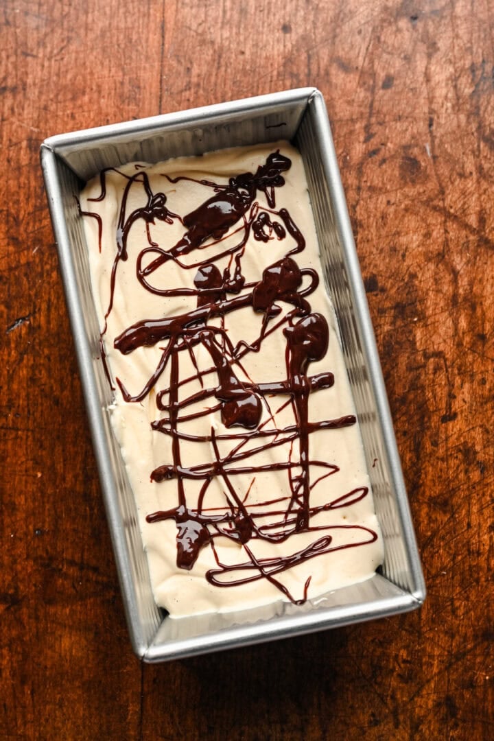 Drizzling fudge atop ice cream base.