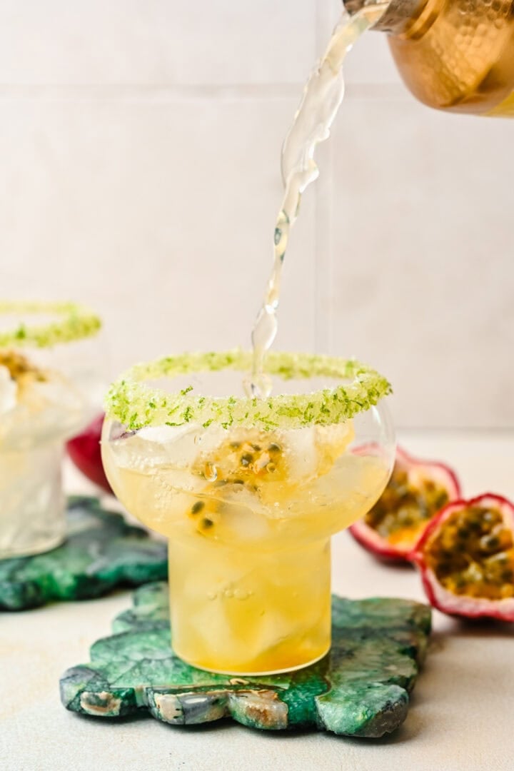 Front view of pouring cocktail into glass.