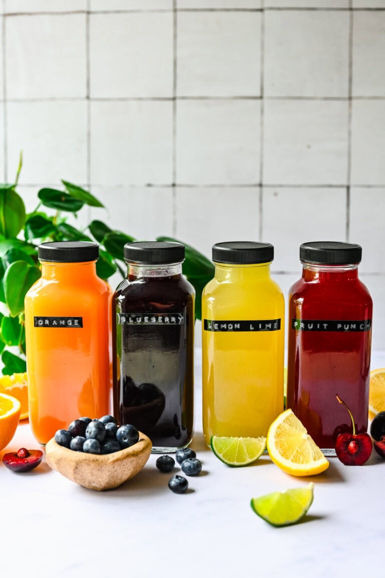 Orange juice, blueberry juice, lemon lime juice, fruit punch, colorful juice bottles with fresh fruit garnishes.