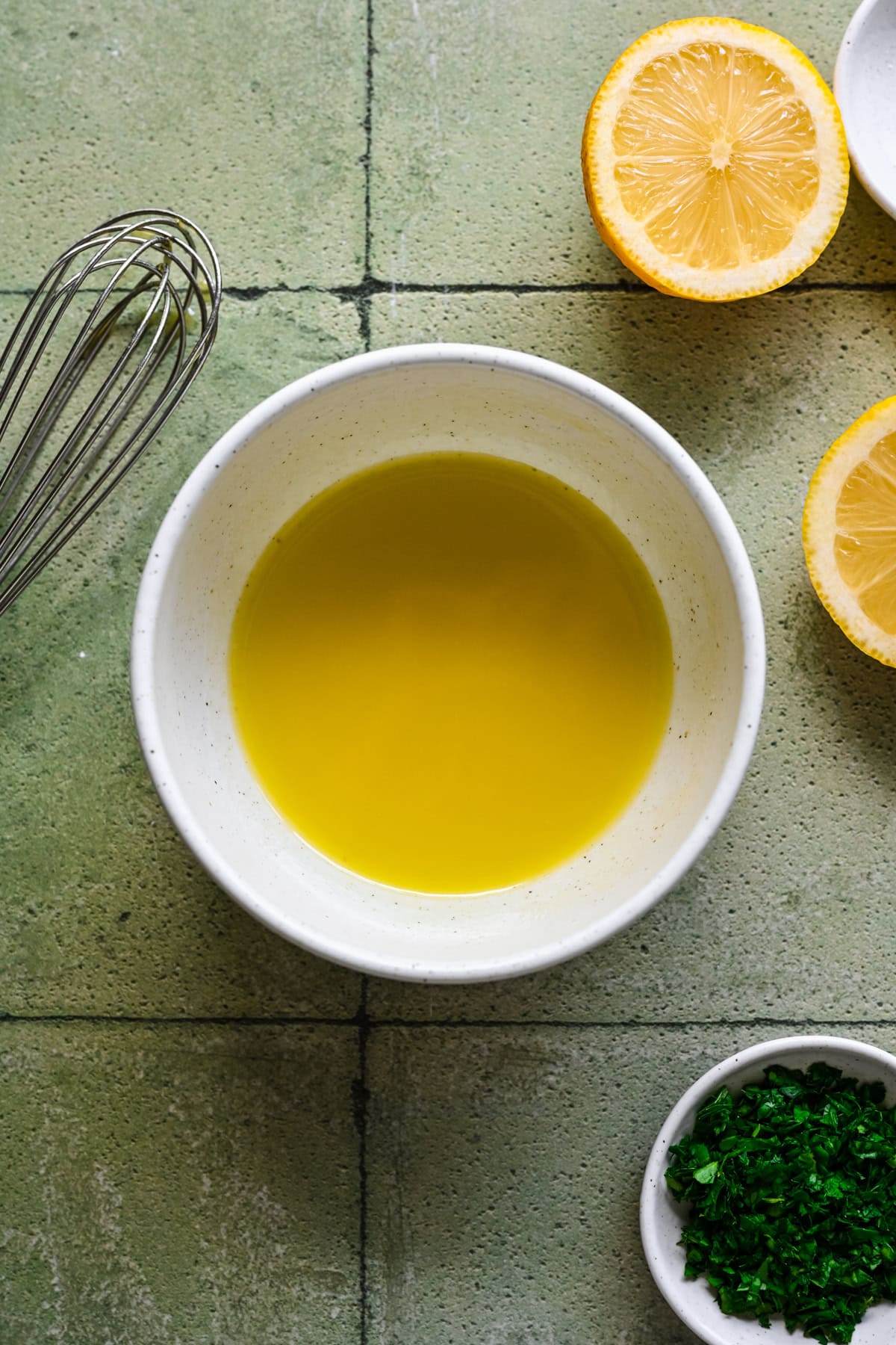 Olive oil and lemon juice whisked together in a bowl.