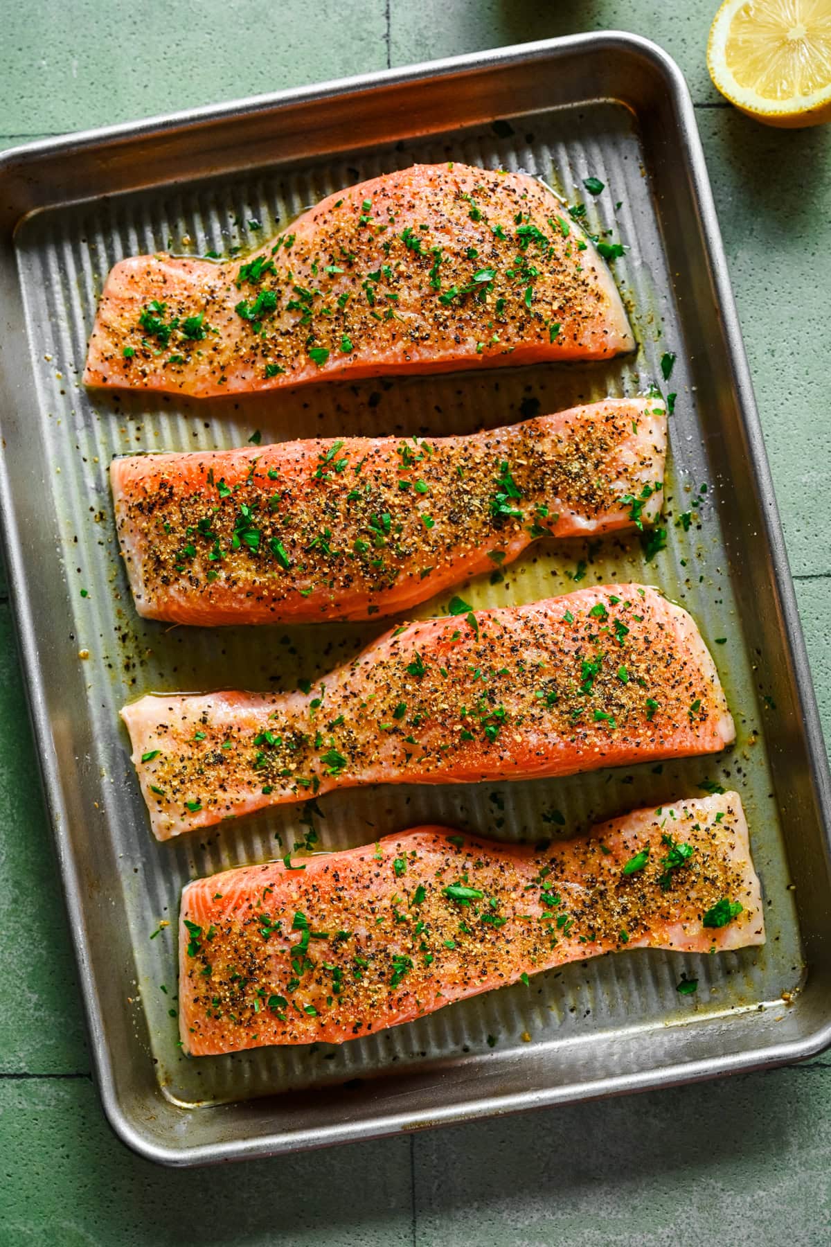 overhead view of lemon pepper salmon on sheet pan before baking.