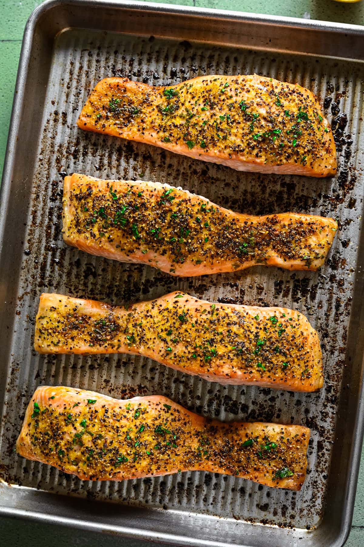 overhead view of lemon pepper salmon on sheet pan after baking.