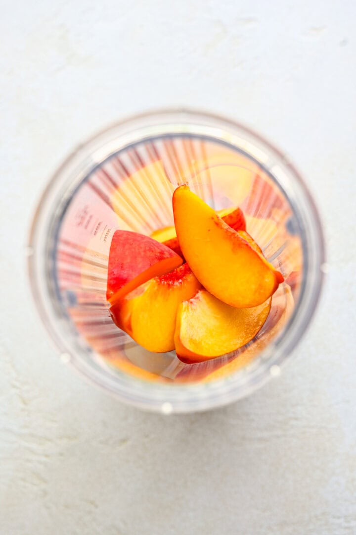 Overhead view of peaches in a bullet blender.