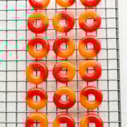 Overhead view of peach rings on a cooling rack.