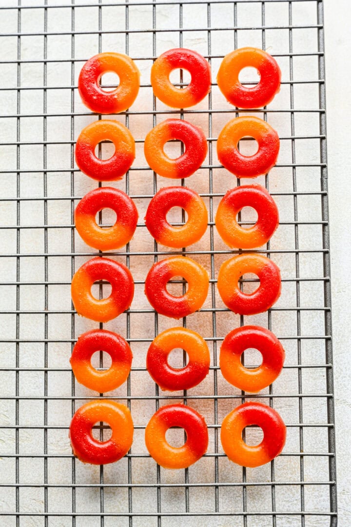 Overhead view of peach rings on a cooling rack.