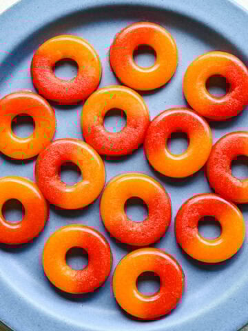 Overhead view of peach rings on a blue plate.