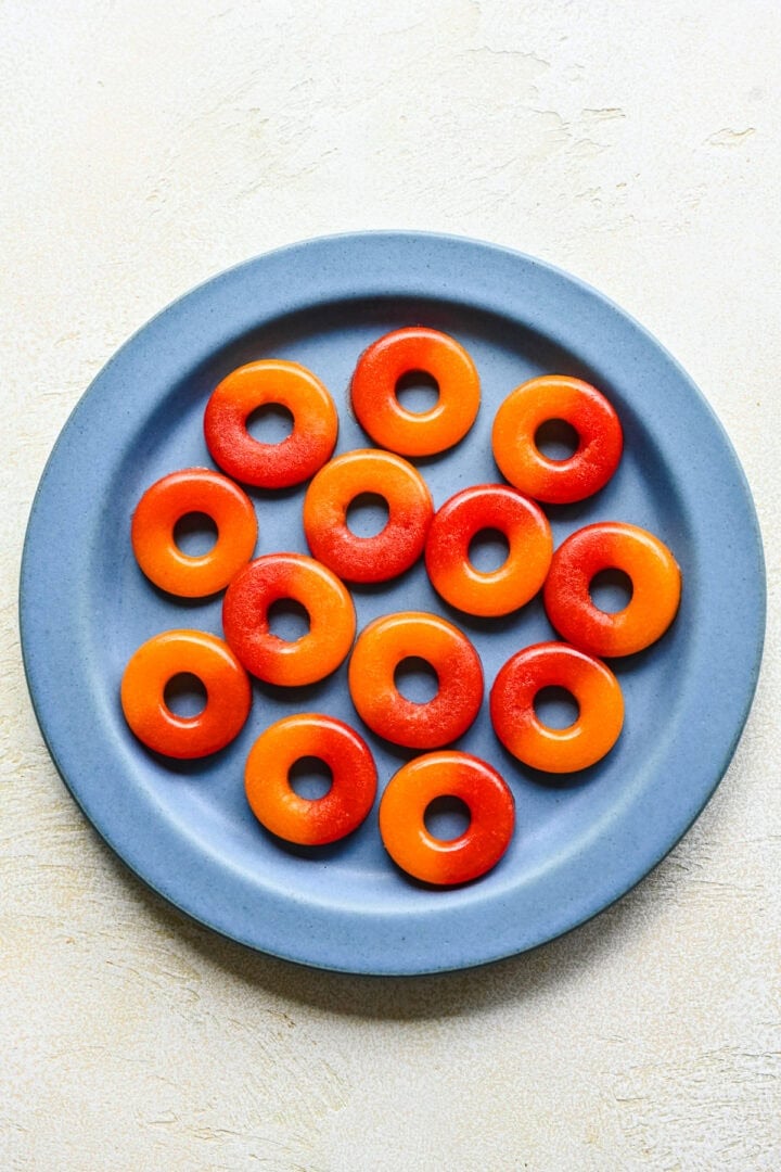 Overhead view of peach rings on a blue plate.